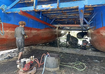 The SEA People Boat Drydock In the Mud Cleaning and Repairing Hulls 2Reef Restoration Coral Gardeners Raja Ampat